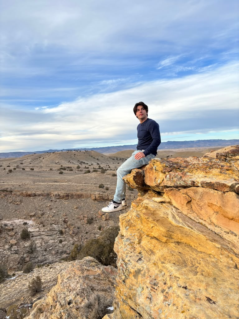 Thomas Hoolihan sitting on a rocky overlook